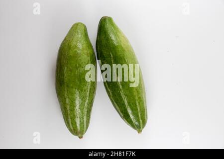 Top view of unripe healthy organic fresh unpeeled pointed gourds isolated on a white background Stock Photo