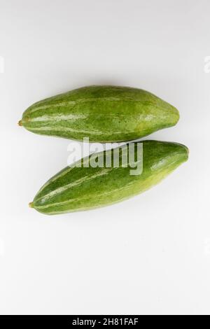 Top view of unripe healthy organic fresh unpeeled pointed gourds isolated on a white background Stock Photo