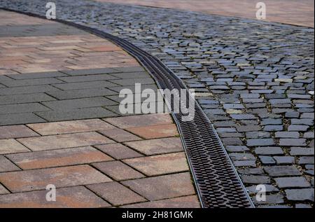 gray andbrown cube granite cobblestone pavement. rectangular shapes loosely set. cement mortar joints. street and walkway paving design concept. Stock Photo