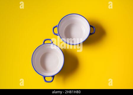 Minimalism style. Empty plates for soup on yellow paper background. Stock Photo