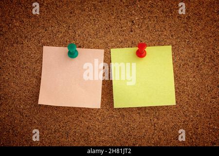 Two blank sticky notes pinned to a cork board. Close up. Stock Photo