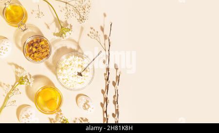 Preparation for Easter. Food holiday composition with ingredients for making Easter cake with white flowers and decor for coloring eggs on a pink back Stock Photo