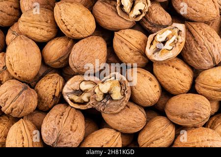 Walnuts with and without shells. Background texture of fresh walnuts. Stock Photo