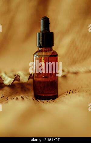 Cosmetic Bottle serum dark glass, oil cosmetic on beige paper background, flat lay, top view, copy space. minimalism brand packaging mock up Stock Photo