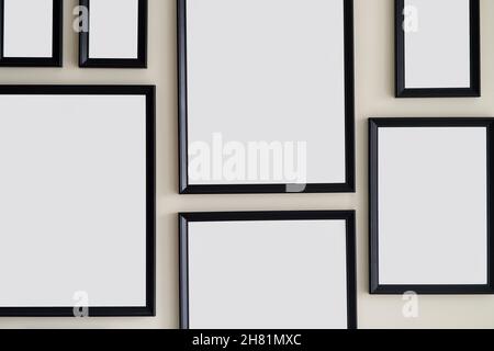 Different size framed photos hanging on the gray wall. Mockup. Stock Photo
