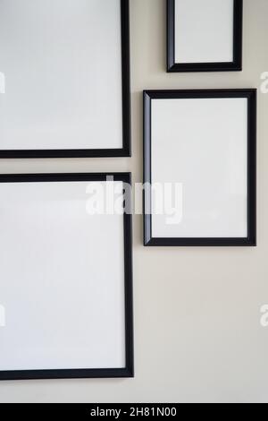 Different size framed photos hanging on the gray wall. Mockup. Stock Photo