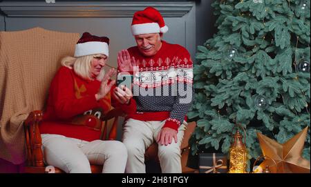 Senior family taking selfie on mobile phone, communicating video call online celebrating Christmas Stock Photo