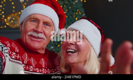 Mature family taking selfie on mobile phone, communicating video call online celebrating Christmas Stock Photo