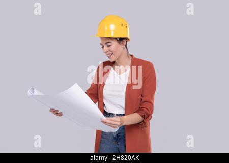 Girl Construction Worker Holding House Plan in Hands Watching at it. Girl Architect Holding Blueprints. Yellow Hard Helmet. Stock Photo