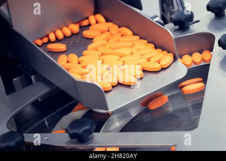 Pharmaceutical production line, production of tablets or vitamins manufacturing, tablet conveyor Stock Photo