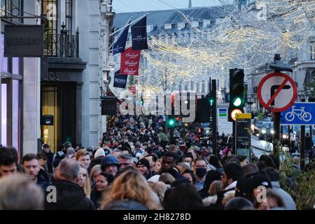 London, UK, 26th Nov, 2021.  Heavy footfall seen along Regent Street as retailers receive a boost on Black Friday. Shoppers laden with bags of festive purchases seemed undeterred by Transport for London's (TfL) Tube strike affecting five underground lines until Sunday morning. Regent Street and Oxford Street got off to a slow start but by the afternoon was bustling with people. Credit: Eleventh Hour Photography/Alamy Live News Stock Photo