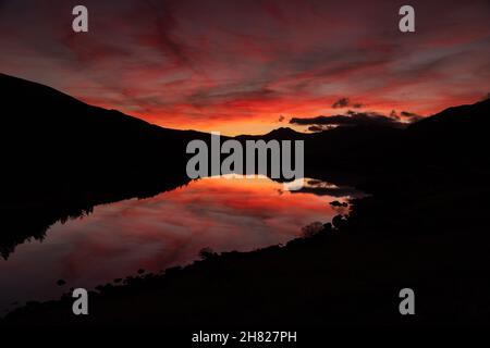Reflection of colourful sky at dusk in Llyn Mymbyr, Snowdonia, North Wales Stock Photo