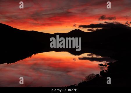 Reflection of colourful sky at dusk in Llyn Mymbyr, Snowdonia, North Wales Stock Photo