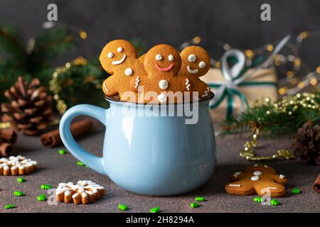 Homemade gingerbread cookies in the form of fabulous gingerbread men and christmas trees in blue cup in new year composition, Close-up Stock Photo