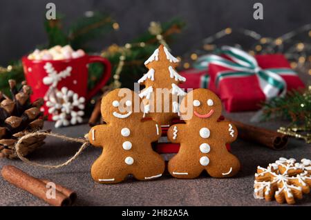 Gingerbread man and christmas tree close up on festive new year background. Homemade sweet pastries for winter holidays Stock Photo