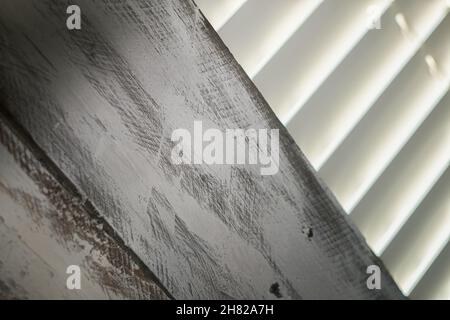 A partially boarded window with closed Venetian blinds. Stock Photo