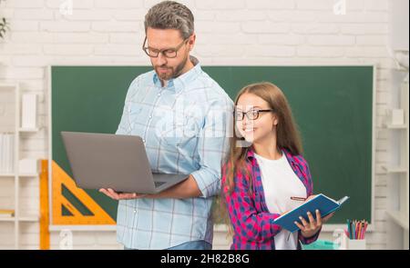 father and teen girl study. private teacher and child hold copybook. family help. dad and daughter Stock Photo