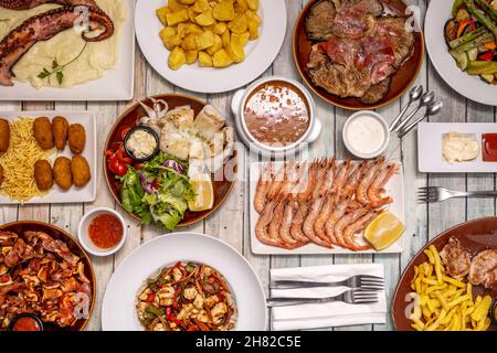 Set of great dishes of Spanish food and tapas, grilled prawns, octopus with potatoes, spicy bravas, grilled cuttlefish, ear, serrano ham croquettes, m