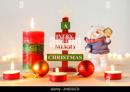 Christmas decorations on wooden table with defocused holiday lights in background Stock Photo