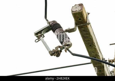 Drop fuse on high-voltage electrical pole supply. Stock Photo