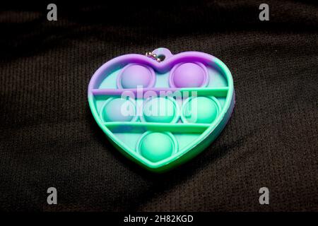 toy pop it in the shape of a heart on a black background in Rio de Janeiro. Stock Photo