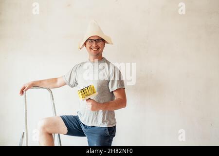 Plasterer home improvement handyman worker makes repairs. Renovation diy new home painting wall. Stock Photo