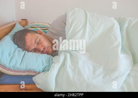 Sleeping guy at home. Relaxed man. Promote prevention and management of sleep disorders Stock Photo