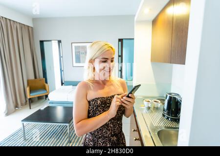 Side view pleasant young woman using smart home system or activating modern alarm system before leaving apartment. Happy lady turning off easy Stock Photo