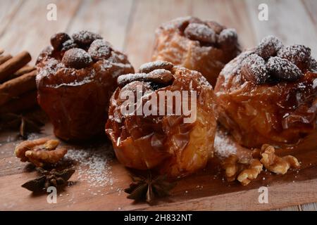 Baked apples with nuts and raisins. Homemade baked apples in the oven, with sugar powder close-up. Holiday dessert Stock Photo