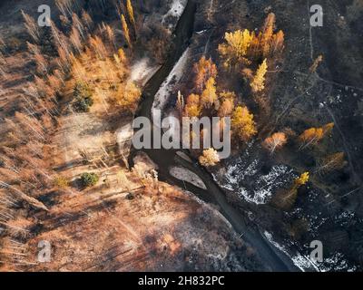 Aerial top view of the mountain river in the autumn yellow forest. Photo taken with Drone Stock Photo