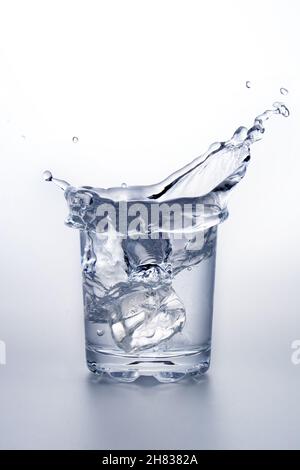 close up of ice cube splash in water on white background Stock Photo ...