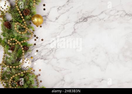 Christmas greeting card or frame with fir tree branches and festive decor on light grey marble background with pine cones.Merry Christmas and happy ne Stock Photo
