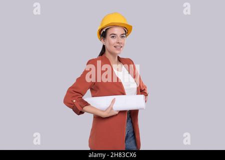 Girl Construction Worker Holding House Plan in Hands Watching at it. Girl Architect Holding Blueprints. Yellow Hard Helmet. Stock Photo