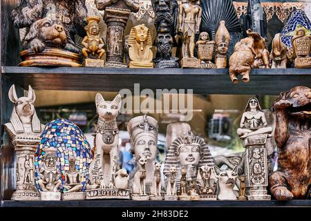 Egyptian figurines depicting gods, pharaohs, animal figurines as souvenirs on shop window shelf Stock Photo
