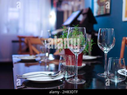 Wine glasses on black table near window with thin curtain Stock Photo