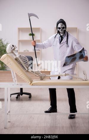 Devil doctor radiologist examining skeleton patient at the hospital Stock Photo