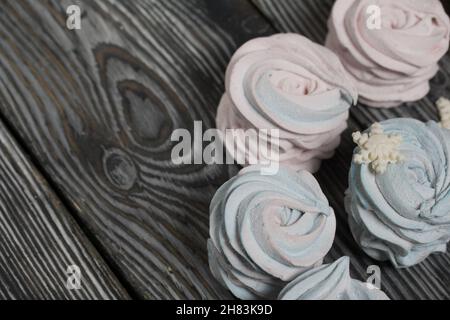 Marshmallow blue and pink. Decorated with mastic snowflakes. On black pine boards. Stock Photo