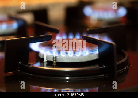 The gas burns in the burner of a kitchen stove. Close up Stock Photo