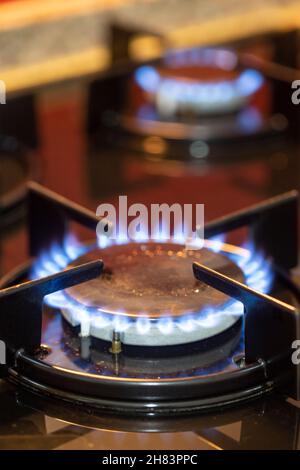 The gas burns in the burner of a kitchen stove. Vertical view. Story format Stock Photo