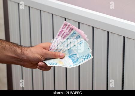 Turkey energy crisis. increase in gas prices in Europe for the population. Turkish lira in front of a burning radiator Stock Photo