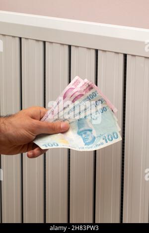 Turkey energy crisis. increase in gas prices in Europe for the population. Turkish lira in front of a burning radiator Stock Photo