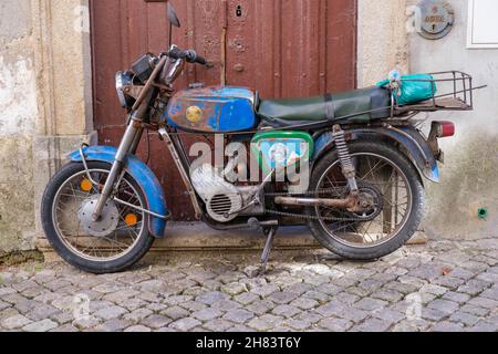 Castelo Branco, Portugal - November 06 2021: Zundapp Falcao motorbike parked in front of a doorway on a cobblestone street in Castelo Branco Portugal Stock Photo