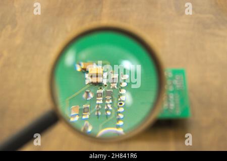 Printed circuit board under a magnifying glass Stock Photo