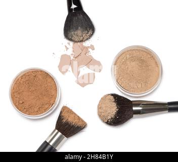 Loose make-up powder in jars, crushed compact powder with makeup brushes on white background Stock Photo