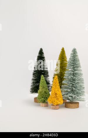 Five Mini Yellow and Green Bottle Brush Christmas Trees on White Background With Vertical Copy Space Stock Photo