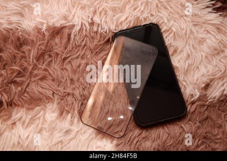 Cracked smart phone screen protector film on carpet Stock Photo