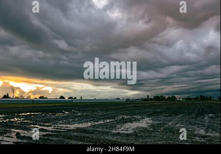 Threatening storm clouds gather at sunset Stock Photo