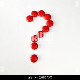 question mark with red Small wooden objects on white paper. Stock Photo