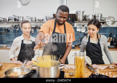 Portrait of African-American man making pasta during cooking class in kitchen interior Stock Photo