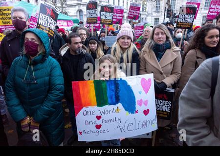 London, UK. 27th Nov, 2021. A protestor holds a sign that says 'One world. One family. Refugees welcome' during the demonstration.Stand Up to Racism UK organized a protest against the Nationality and Borders Bill introduced by the Tory government. They called on the Boris Johnson and Priti Patel to open doors to more migrants, in light of a recent drowning of migrants on their way to the UK. Credit: SOPA Images Limited/Alamy Live News Stock Photo